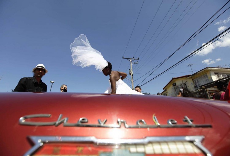 Bride Dayami Tellez of Havana, Cuba, boards a 1958 Chevrolet Impala convertible car after her wedding with groom Joaquin Camacho of Spain in Havana March 21, 2012. REUTERS/Desmond Boylan (CUBA - Tags: SOCIETY TRANSPORT TPX IMAGES OF THE DAY) ORG XMIT: HAV01